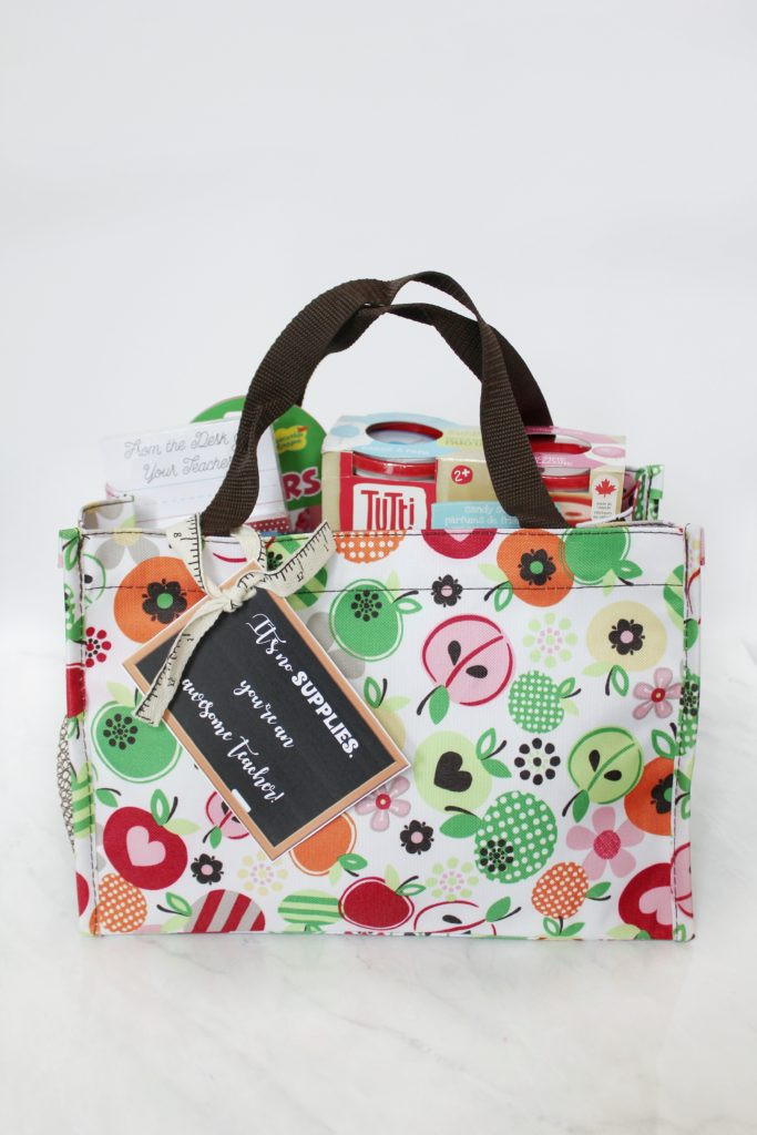 A gift bag filled with school supplies like markers, sticky notes, and stationery.