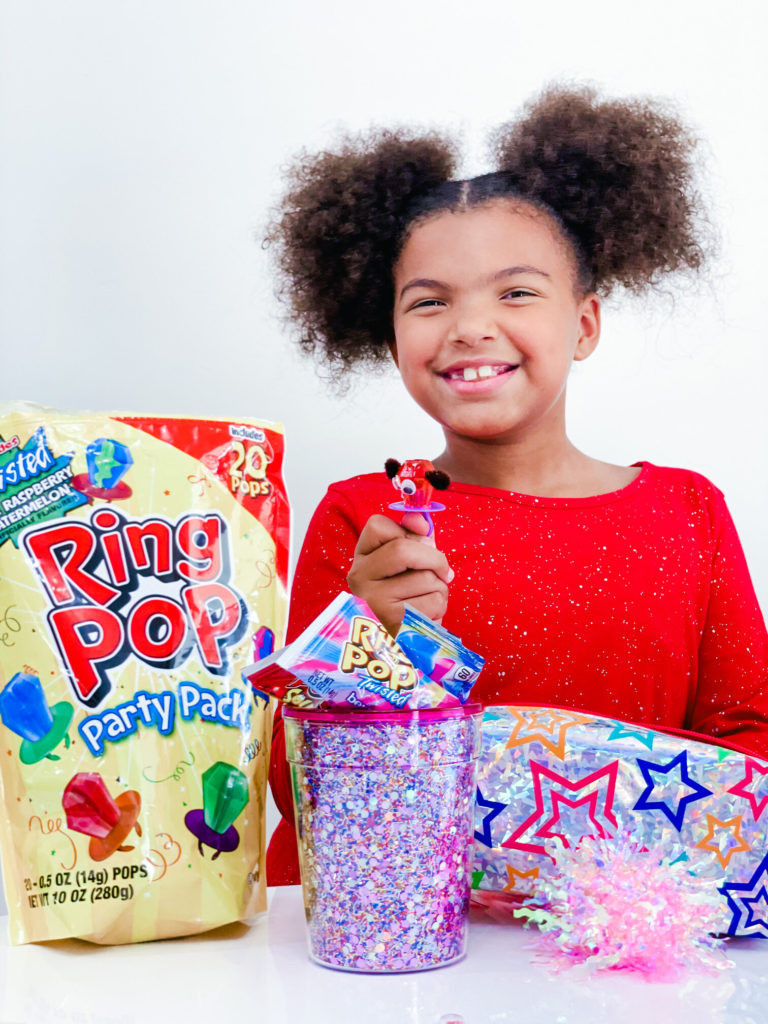 alt: A child happily displaying their self-made Ring Pop character craft, embodying the fun and creativity of back-to-school projects with Ring Pops.