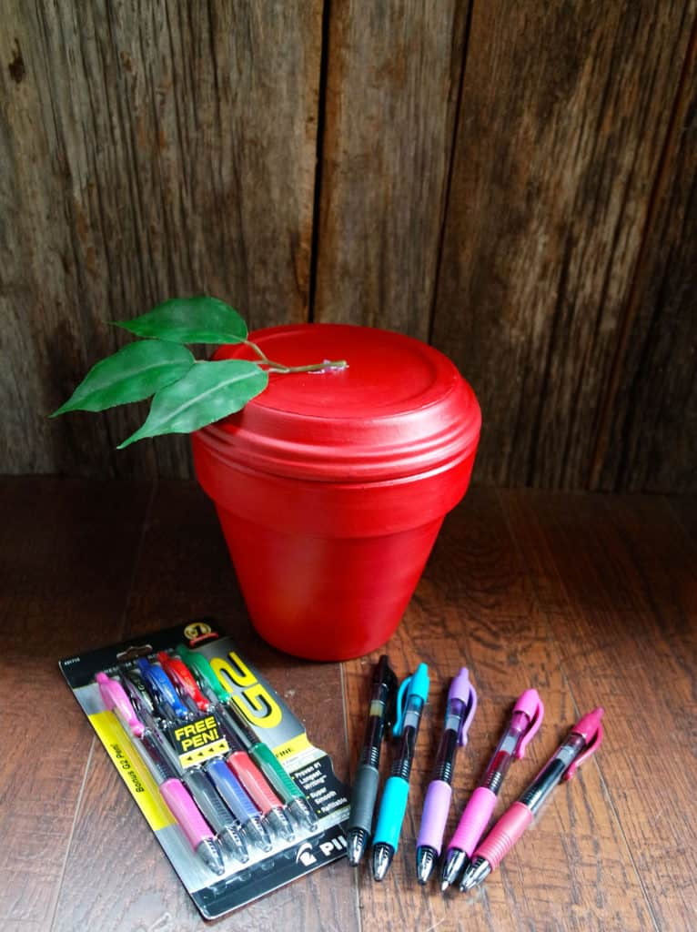 alt: A colorful pencil pot filled with Pilot G2 pens, decorated with wrapping paper and a ribbon.