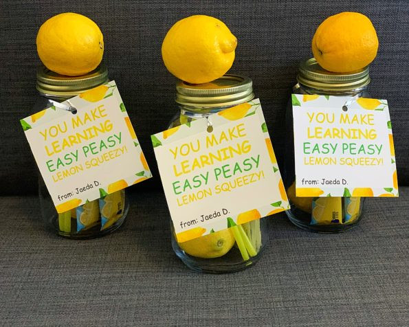 Lemonade in mason jars with lemons, straws, and labels.