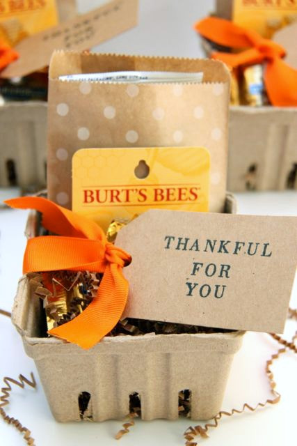 Small gift basket with fall treats like mini pumpkins, apples, and cider.
